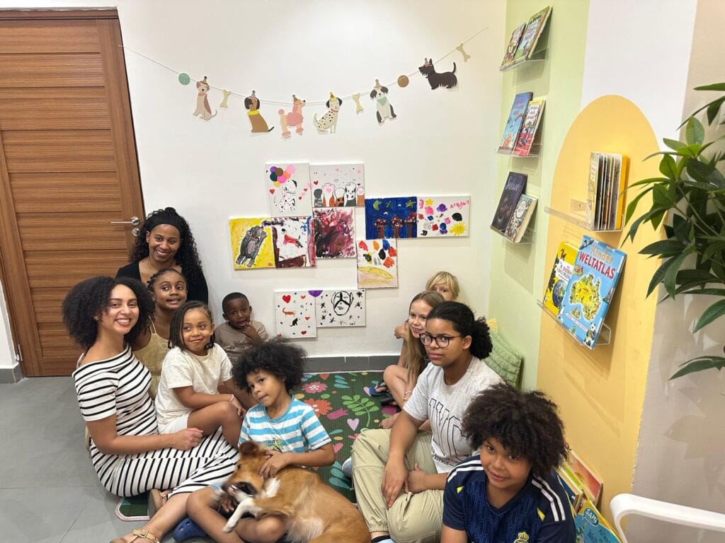 Group of children and adults together in the Studyfreunde reading corner in Accra