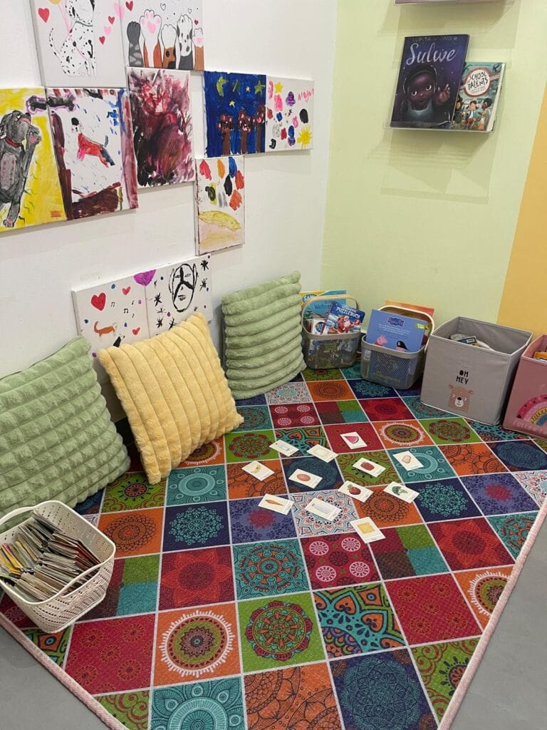Reading corner of the German playroom with cushions, picture books and learning materials