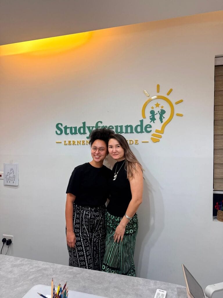 Two women in front of the Studyfreunde logo, German lessons in Airport West, Accra