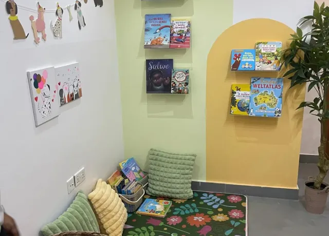 German children's library corner with picture books, cushions and a play rug